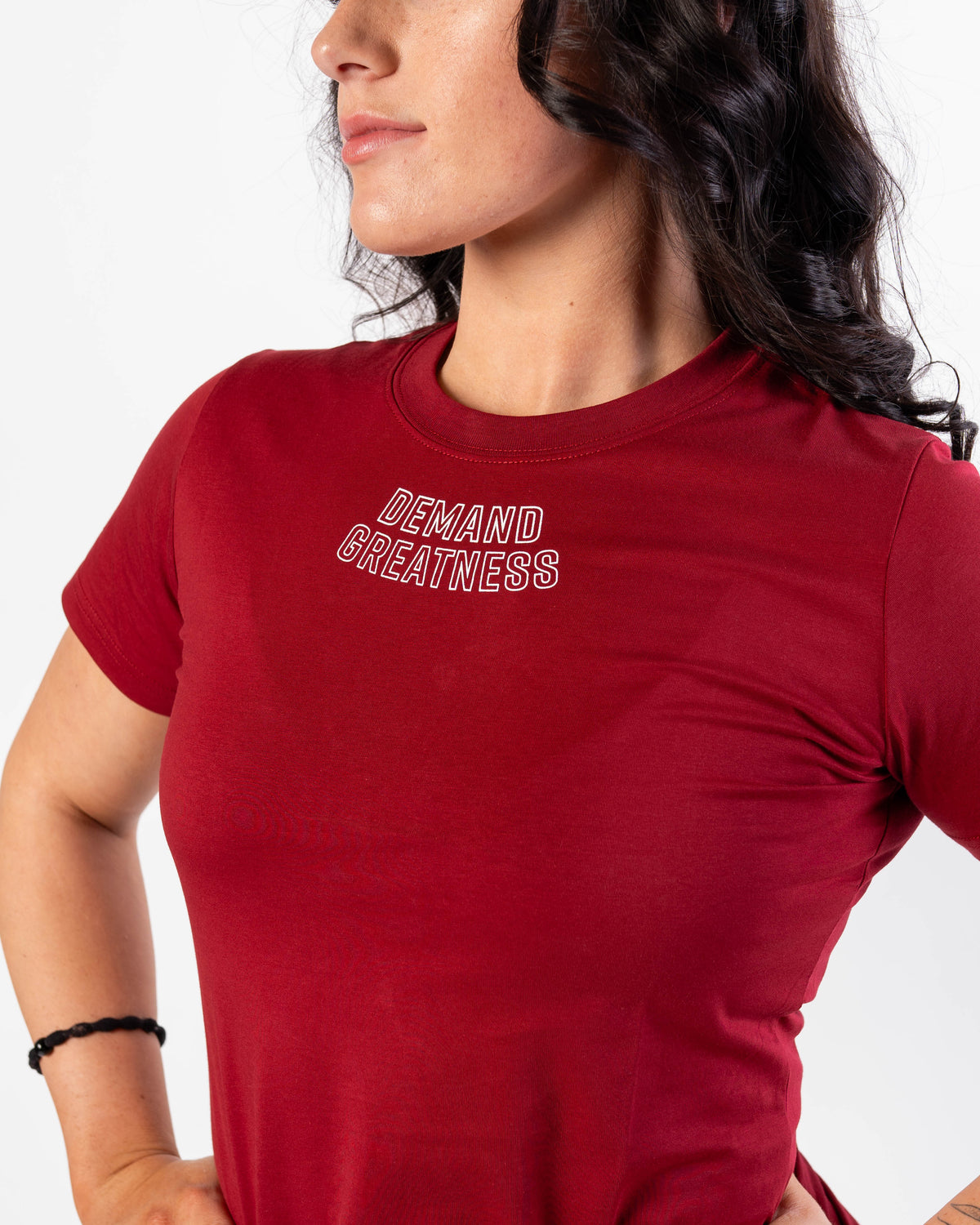 Close up of DEMAND GREATNESS text on the top of center chest of meet shirt to show underneath singlet